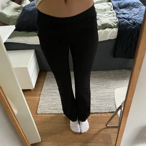 Svarta kostymbyxor med bootcut - Säljer ett par svarta kostymbyxor med bootcut passform och medel midja. Byxorna har en klassisk look och är perfekta för en stilren outfit. Materialet känns mjukt och följsamt.