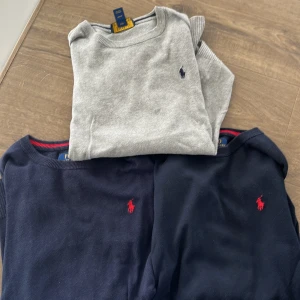 3 st tröjor från Polo Ralph Lauren - Säljer tre klassiska tröjor från Polo Ralph Lauren i storlek L (14-16). Två är mörkblå med röd logga och en är ljusgrå med marinblå logga. Alla har rund halsringning och är tillverkade i mjuk bomull. Skicket är ganska bra och är använda. L i barn storlekar men passar xxs 
