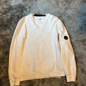 Vit sweatshirt från C.P. Company - Säljer en stilren vit sweatshirt från C.P. Company. Är XL sitter som L. Nypris är 2000.  Kan kolla om jag kan hitta kvitto också