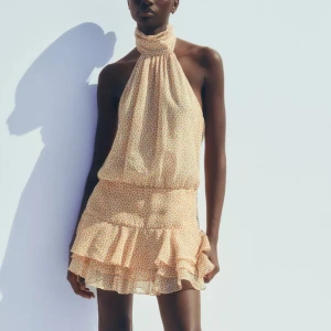 Blommig halterneckklänning med öppen rygg Zara  - Supersöt kortklänning med halterneck och volangkant nertill. Faller så fint på kroppen! Helt ny med lapparna kvar. Säljer för 450kr alternativt byter mot en L🍋