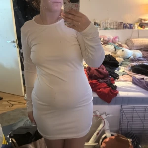 Rosa långärmad klänning från Gina Tricot - Säljer en rosa, tight långärmad klänning från Gina Tricot i storlek XL. Klänningen har en snygg öppen rygg med volangdetalj och är tillverkad i ett mjukt, stretchigt material. Perfekt för dig som gillar stilrena och enkla plagg med en twist.