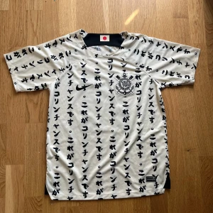 Corinthians fotbollströja Strl M (Sällsynt) - Unik vit fotbollströja från Corinthians med svarta japanska tecken över hela tröjan. Klubbens emblem på bröstet, Nike-logga och japansk flagga i nacken. Nummer 15 och namnet Paulinho på ryggen. Perfekt för samlare eller fans.
