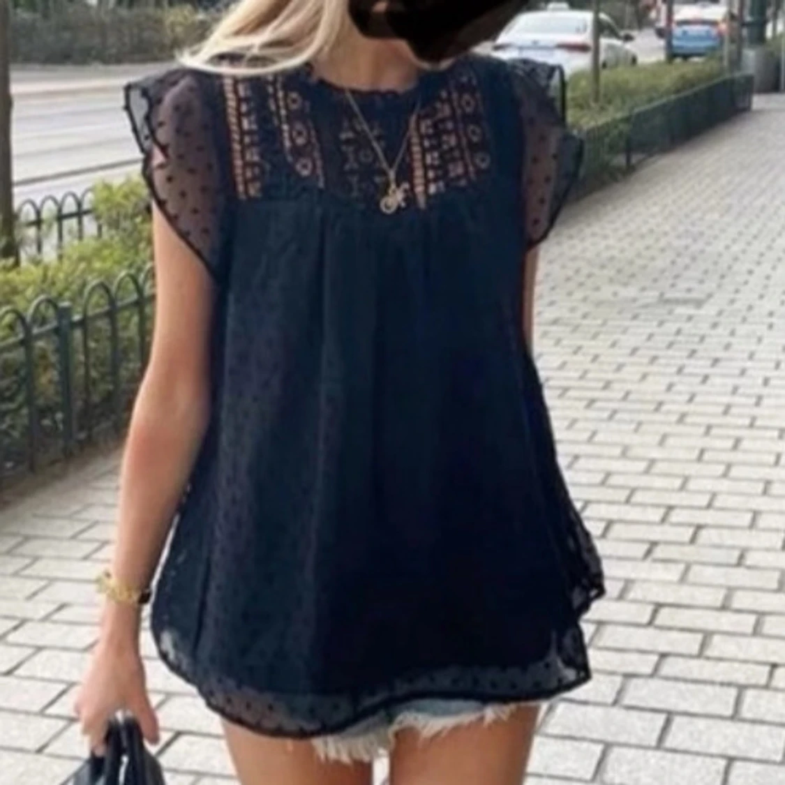 Svart blus med prickig mesh och volangärm