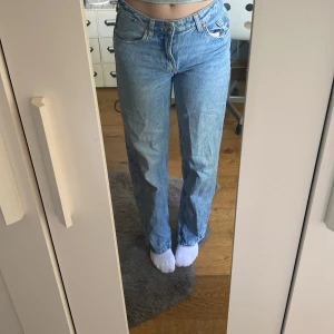 Ljusblå raka jeans - Säljer ett par ljusblå jeans med rak passform och klassisk femficksdesign. Jeansen har hög midja och är tillverkade i ett mjukt denimtyg. Perfekta för en avslappnad och stilren look.