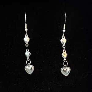 Silverfärgade örhängen med hjärtan - Handgjorda och unika silverörhängen 🤩 Öronhängerna är nickelfria och silverpläterade i kirurgiskt stål, resterande av örhänget är i rostfritt stål (ej silverpläterat) 💕🙏 4 cm långa. Alla köp görs via ”KÖP NU” knappen.  💐
