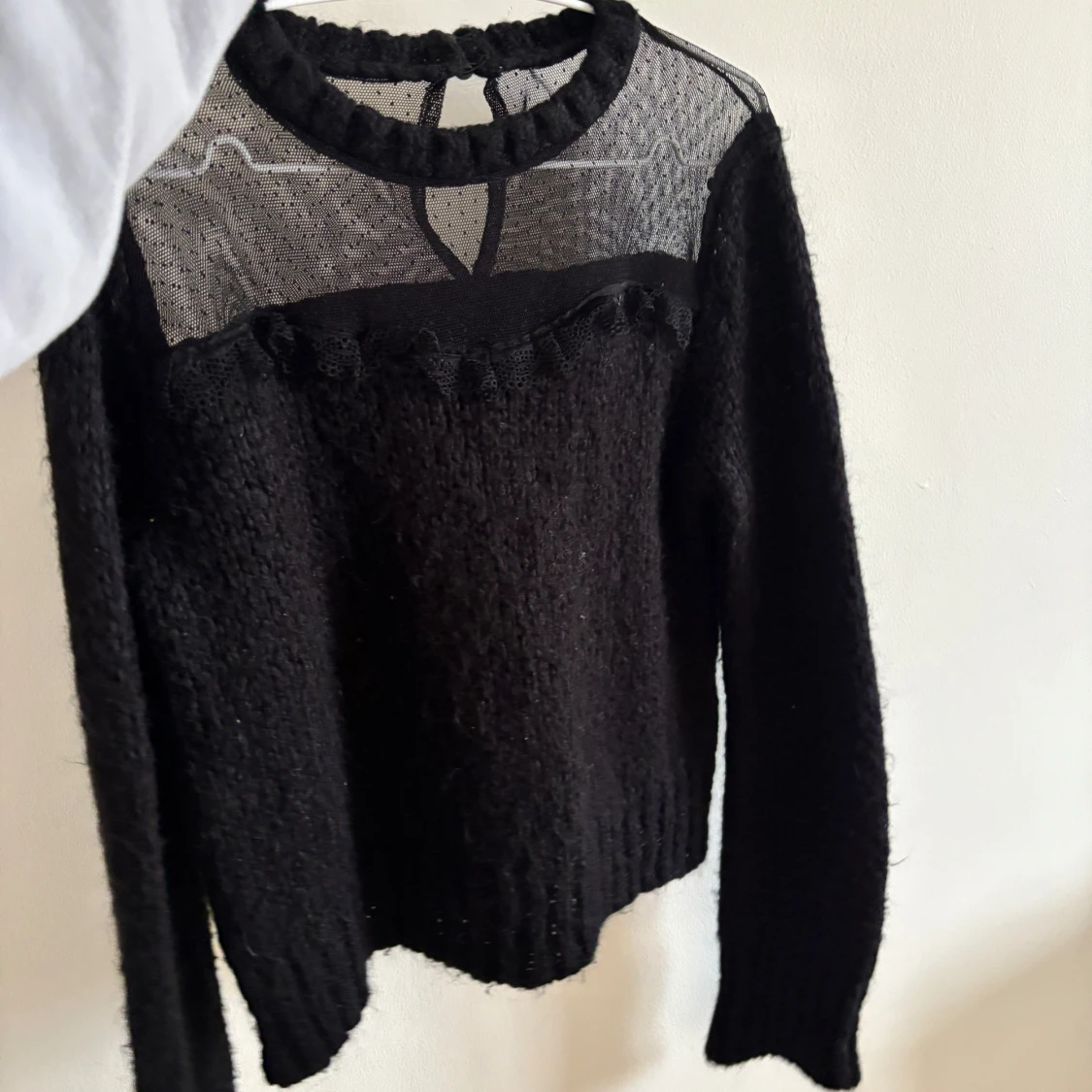 Svart stickad tröja med mesh och volang - 1