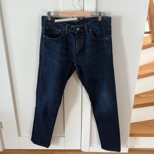 Levi's 520 jeans i mörkblå denim - Mörkblå Levi's 520 jeans med klassisk femficksdesign och raka ben. Jeansen har normal passform och är tillverkade i slitstark denim med snygga kontrastsömmar. Perfekta för dig som gillar en tidlös och enkel stil.