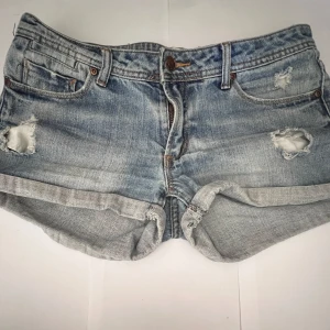 Lågmidjade Ljusblå shorts  - Säljer dessa ljusblå lågmidjade jeansshorts från Cdenim med slitna detaljer och upprullade benslut. Klassisk femficksmodell med knapp och dragkedja framtill.  I mycket bra skick. Perfekta nu inför sommaren☀️storlek S