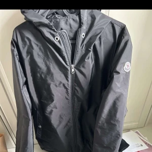 Svart vindjacka från Moncler - Snygg svart vindjacka från Moncler skriv för fler bilder bättre pris vid snabb affär snören finns också