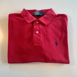 Röd pikétröja från Ralph Lauren - Klassisk röd pikétröja från Polo Ralph Lauren!                 Säljs då den blivit för liten för mig men är fortfarande i toppskick!                                                                          Använd bara ett fåtal gånger så är som ny!           Priset är inte hugget i sten!