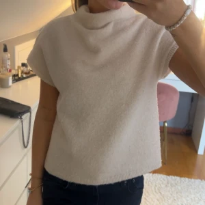Beige stickad tröja  - Superfin beige stickad polotröja utan ärmar. Tröjan är ifrån Lindex!