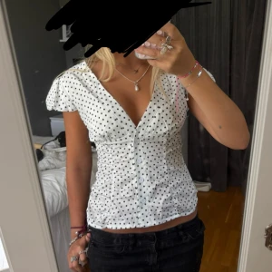 Vit prickig blus - Supersöt vit blus med svarta prickar. Passar perfekt till vardagen med ett par jeans eller om man ska klä upp sig. Den är i storleken XS. Säljer då jag har en liknande redan och dehär inte kommer till användning. Den är aldrig använd så är i superbra skick.💓