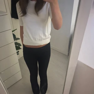 Vit kortärmad topp i bomull - Enkel och stilren vit topp med korta ärmar och rund hals. Modellen är rak och något croppad, vilket ger en modern vibe. Tillverkad i mjuk bomull som känns skön mot huden. Perfekt att matcha med jeans eller kjol.