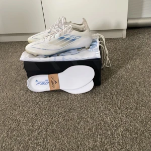 Adidas F50 Elite FG Polar victory  - Säljer ett par Adidas F50 Elite FG fotbollsskor från Polar Victory paketet. Perfekta för spel på naturgräs. Innersulor och originalkartong medföljer. Skorna är endast använda en träning och har därför ett skick på 9,5/10 då man knappast ser att dem är använda även fast de är vita. De är köpta för 3099kr och säljs endast för 1999. Kom med förslag!