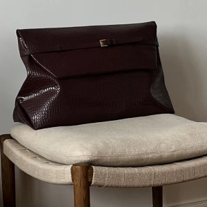 Stor brun kuvertväska i krokopräglat skinn - Oversized kuvertväska i burgundy från H&M A/W, slutsåld överallt. Som ny, endast använd enstaka gång! 