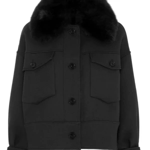 Svart pälsjacka från Meotine XS/S - JÄTTEFIN kappa från Meotine I modellen Charlie i storlek XS/S. Jackan har en oversized passform, stora bröstfickor med lock (utan knappar)men med  knappar framtill. Kragen är i fluffig pälsimitation som ger en lyxig vibe. Perfekt för kalla dagar när du vill vara både varm och snygg. Nypris 3000.