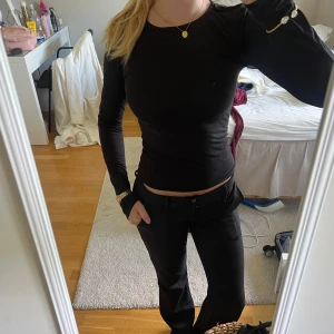 Svart långärmad tight tröja - Säljer en svart långärmad tröja med tight passform. Tröjan har rund halsringning och är gjord i ett stretchigt material som sitter snyggt mot kroppen. Perfekt att styla med jeans eller kostymbyxor för en clean look.