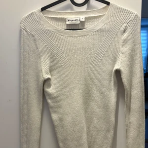 Vit ribbad stickad tröja Kappahl S - Vit stickad tröja från Kappahl i storlek S. Tröjan har ett ribbat mönster med snygga detaljer över axlar och bröst, rund halsringning och långa ärmar. Perfekt för lager-på-lager och enkel att matcha med jeans eller kjol.
