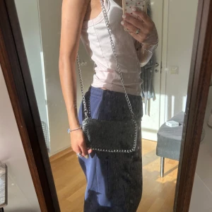 Svart axelväska med kedja från TIAMO - En liten TIAMO väska jag köpt på Plick för ett tag sen, några sminkfläckar i väskan som va där när jag köpte den dock inget jag tänkte på. Säljer på grund av att jag inte använder den längre. 