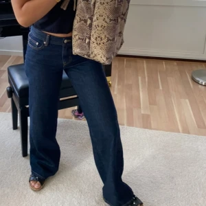 Mörkblå wide jeans med lågmidja - Snygga mörkblå jeans med wide fit och låg midja. Klassisk femficksmodell i jeansmaterial, perfekta till allt. Stilrena och enkla att matcha med olika toppar.
