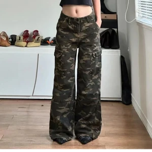 Cargobyxor i camo med wide fit - Säljer dessa skitsnygga cargobyxor med camouflage-mönster med en baggy fit. Inköpta på Urban Outfitters men de är tyvärr för långa på mig som är 158. Byxorna har elastisk midja så trotts att de är storlek S kan de sitta bra på dig med större storlek. 
