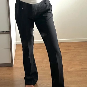 Svarta raka kostymbyxor - Snygga svarta kostymbyxor från BikBok med raka ben och klassisk passform. Byxorna har hällor för bälte och bakfickor. 