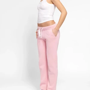 Ljusrosa mjukisbyxor med snörning - Säljer ett par ljusrosa mjukisbyxor med vita snören i midjan och raka ben. Byxorna har en relaxed fit och är perfekta för chill dagar. Mjukt material och fickor på sidorna gör dem extra bekväma. Sparsamt använda går att köpa hela sättet av mig ifall man vill 