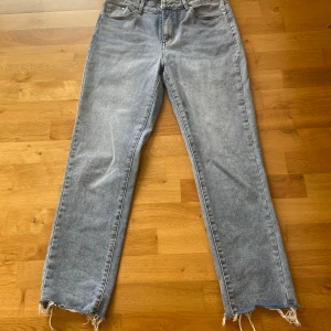 Ljusblå raka jeans från Vila - Säljer ett par ljusblå jeans från Vila med raka ben och råa, fransiga benslut. Klassisk femficksmodell i bomull med normal passform. Perfekta för en avslappnad och trendig look.