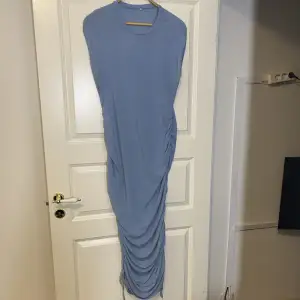 En ljus blå klänning som man kan spänna åt på sidorna 