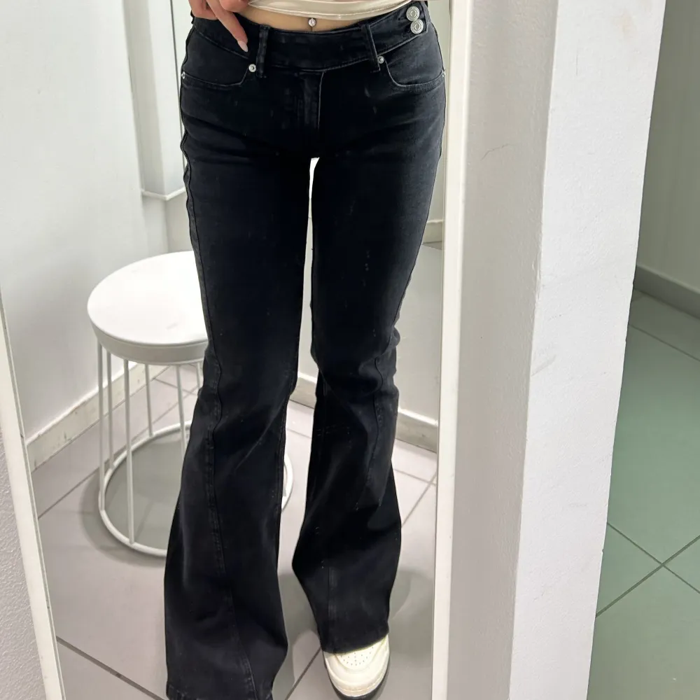 Grå/ svarta låg midja de bootcut jeans med cool detalj. Endast testade. Sitter perfekt på mig som är 165 cm🖤. Jeans & Byxor.