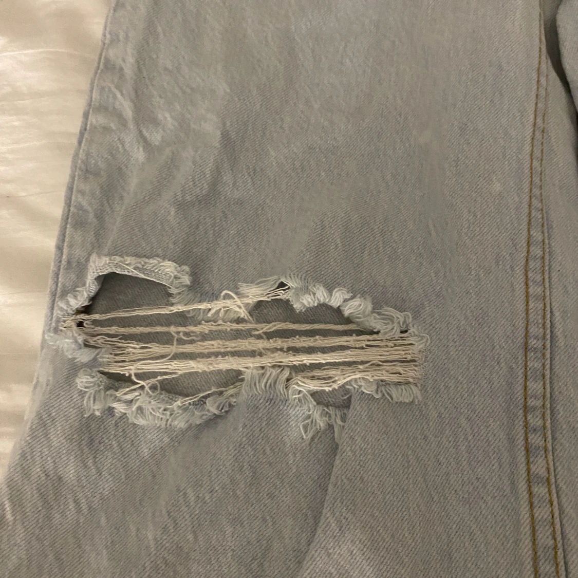 Ljusblåa jeans med slitet hål - 91