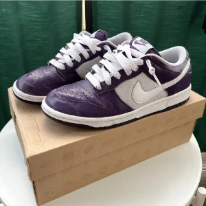 Nike Dunk Lows - Nike dunks lows från 2009. Riktigt feta och modellen heter ”Grand Purple” Väldigt sällsynta och säljs nya online för över 1800kr! De är äkta och alla tillbehör följer med som tex lådan. Sitter som 41.5!! Kan skicka fler bilder eller svara på frågor i DM! 