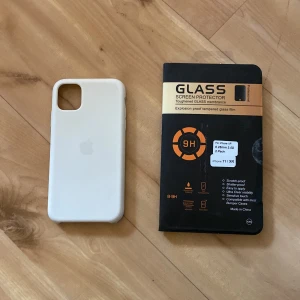 iPhone skal + skärmskydd - Apple silikonskal i vit till IPhone 11, gått sönder lite längst ner. Oanvänt skärmskydd till iPhone 11. 