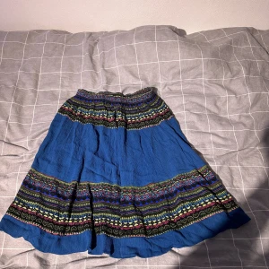 Kjol  - Köpt i Thailand. Slutar lite ovanför knäna. Aldrig använd. Fin till sommaren med ex vit topp💕lätt att vika upp eller du in som man vill eftersom den är mönstrad 