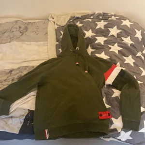 WHO’s A.C.E - En huvtröjan som är i ganska bra skick förutom en liten metall bit som saknas på där man ska spänna så luvan blir tajtare, men annars så är de i bra skick 