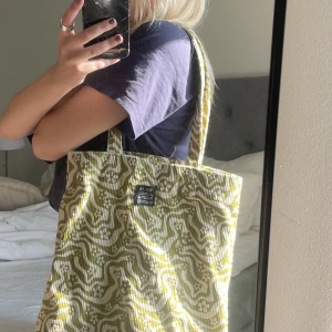 Grön tygväska - Superfin grön och vit mönstrad väska i manchester tyg, köpt ca 1 år sen på Urban Outfitters. Nyskick, knappt använd. Skriv för fler bilder/frågor !😌 (nypris 300kr, priset går att diskutera)