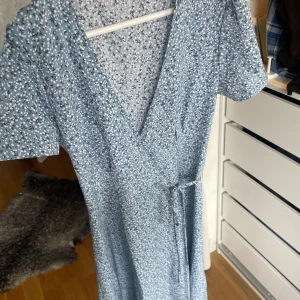 Blommig klänning - Säljer denna supergulliga blommiga klänningen som tyvärr inte kommer till användning. Den är bara använd någon enstaka gång. Passar på mig som vanligtvis har s men eftersom den är omlott är den justerbar så passar nog xs-m