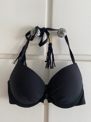 Bombshell bikiniöverdel med knytband, 75A - Vadderad bikiniöverdel med knytband och dekorativ ring på framsidan från Lindex Storlek 75A Använd två gånger, gott skick! 