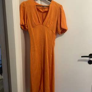 En orange långklänning med slits framtill från NAKD. I storlek M och i väldigt fint skick. Nypris 600