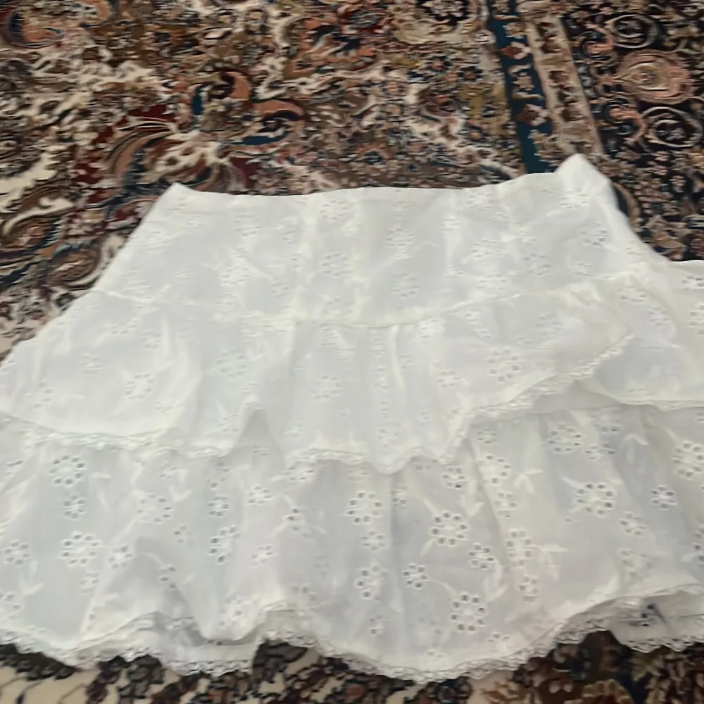 Vit kjol med små hål i 💗 aldrig använd bara testad💗kjolen passar S och Xs💗den är inte alls genomskinlig för den har ett lager under 💗köpt för 250 säljer för 100. Kjolar.