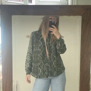 Tunn skjorta i mesh - Tunn skjorta i mesh och ormskinnsmotiv. Skicka meddelande vid köp, PRIS INKLUSIVE FRAKT