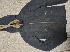 Vinterjacka  - Den är svart men den ser marinblå ut på bilderna pga ljuset. Den är använd 3-4 gånger. Inga hål och alla kedjor fungerar. Den är jätte varm ich har bra skick.