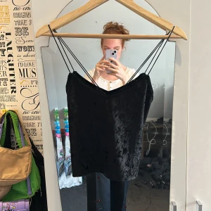 Svart linne - Svart linne i velvet material från New Yorker i storlek S. Tunna spaghetti straps som korsar i ryggen och urringning.