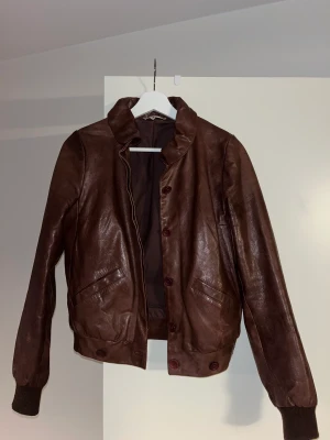 Ba&sh läderjacka 🤎 - Säljer min fantastiska skinnjacka från ba&sh. Den är i strl 1 (XS) men passar mig som bär S. Perfekt till vår och höst! Bild 3 ser ni färgen något bättre - verkligen brun/burgundy. Några år gammal men i gott skick! Nypris: ca 4000kr. 