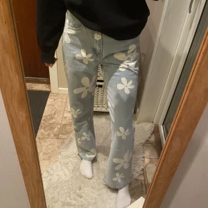 Ljusblåa jeans med tryck  - Ljusblåa raka jeans med vita blommor på från Shein💙Använda 1 gång och har inga fel. Strl. XS, jag är 170+ och jeansen nuddar nästan marken.