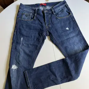 Mörkblåa Guess Jeans med lite slitningar. Använda fåtal gånger. 