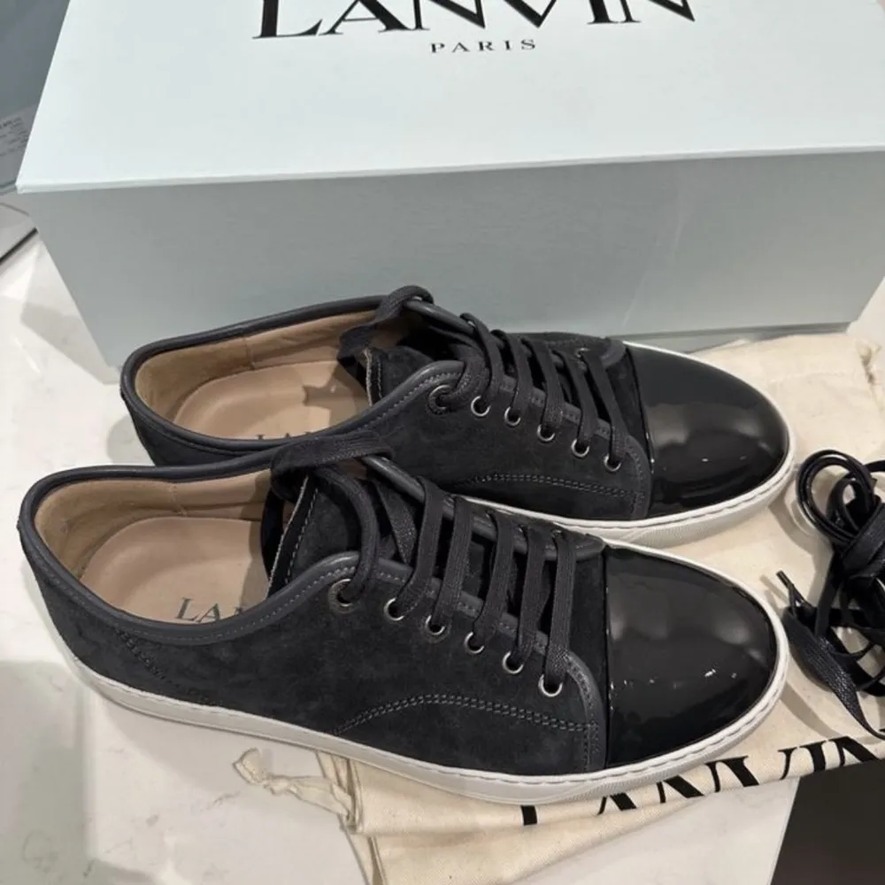 Lanvin (mörk grå)  Patent Cap Toe Sneaker Dark Grey. Storlek 40,  UK6 (stor i storleken) Skick 10/10. Alla tillbehör som Kartong, skosnören, skopåsar finns. Oanvända , självklart original, kvitto finns! . Skor.