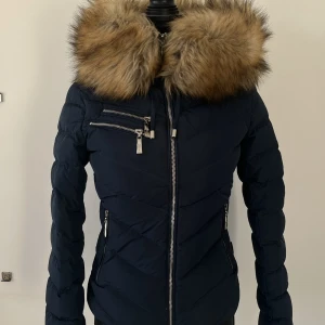 Hollies vinterjacka - Hollies jacka med avtagbar krage i oäkta päls! Så snygg och perfekt till vintern. Väldigt bra skick