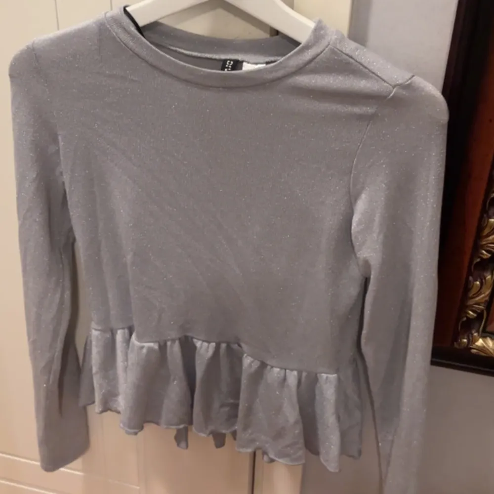 Säljer denna gråa tröja från H&M med volanger nedtill 💗. Tröjor & Koftor.