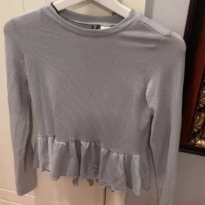 Grå tröja  - Säljer denna gråa tröja från H&M med volanger nedtill 💗